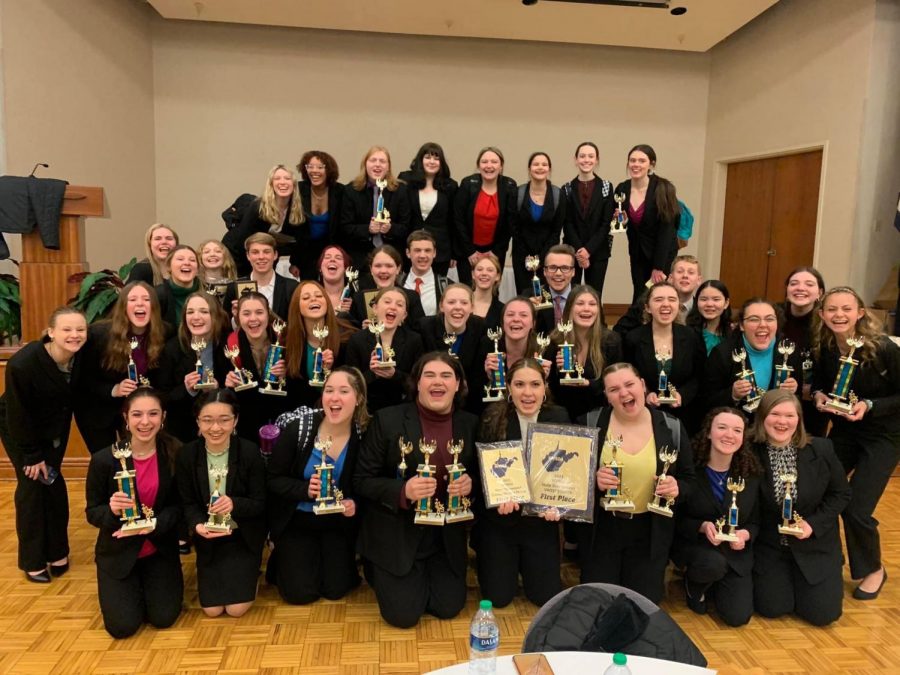 The Speech and Debate Team celebrate in Morgantown after their monumental 43rd consecutive State Title. Members of the team are holding their trophies and the overall sweepstake award.