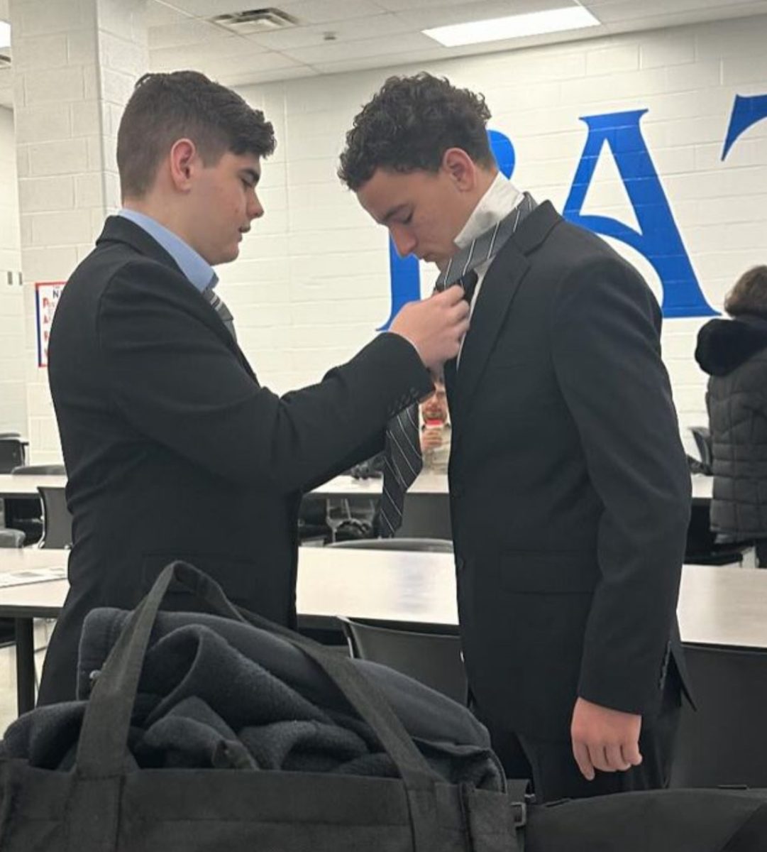 Cash Givens adjusts the tie of his duo interpretation partner, Jerome Maynard, at the Winter Classic tournament. 