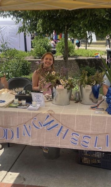 Adeline Schimnoski sells flowers at the Budding Wheeling tent during an event over the summer. 