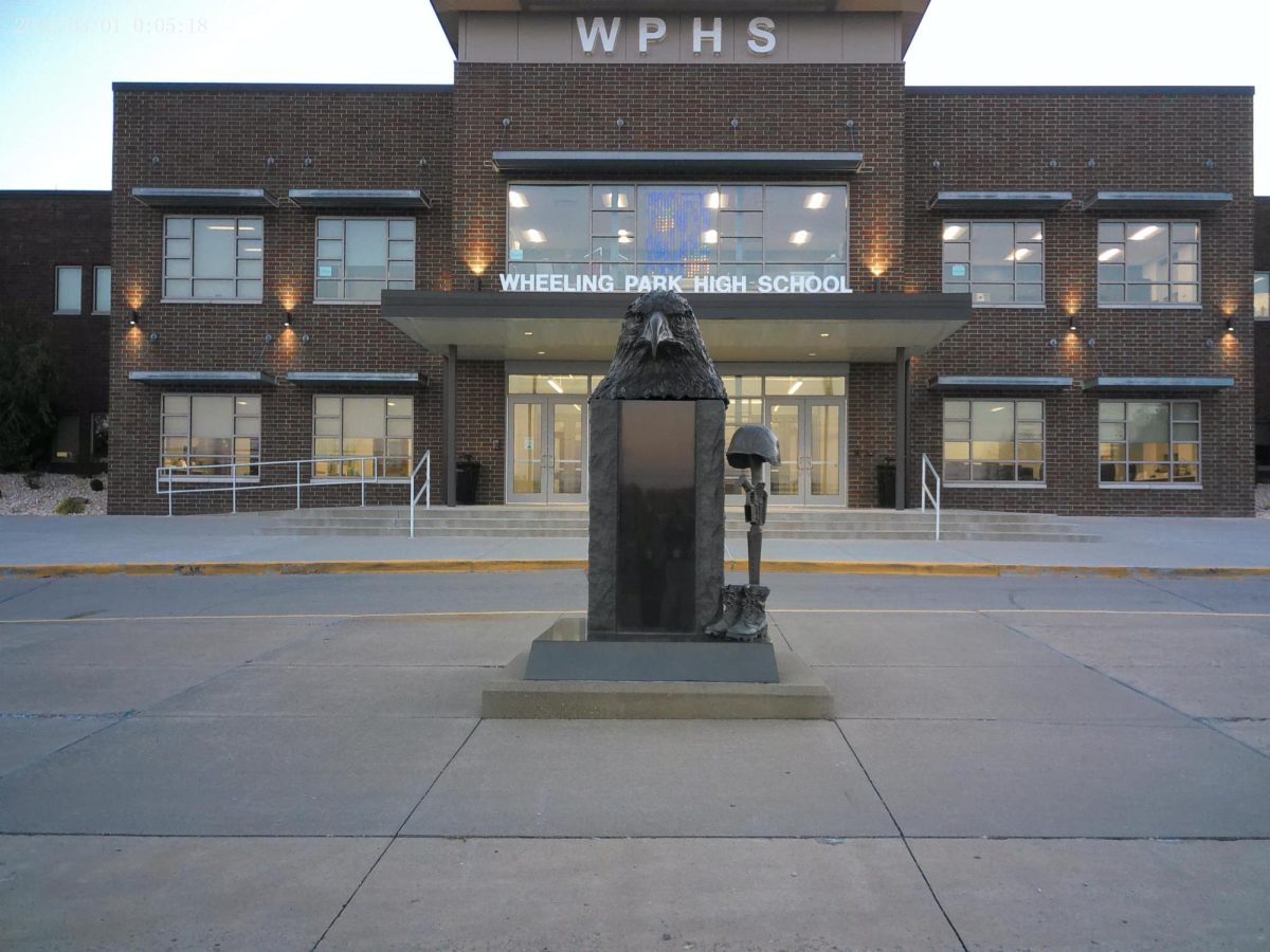 The statue prominently displayed at the main entrance of our high school awaits the unveiling of a new way to honor our veterans on 11/12/24.