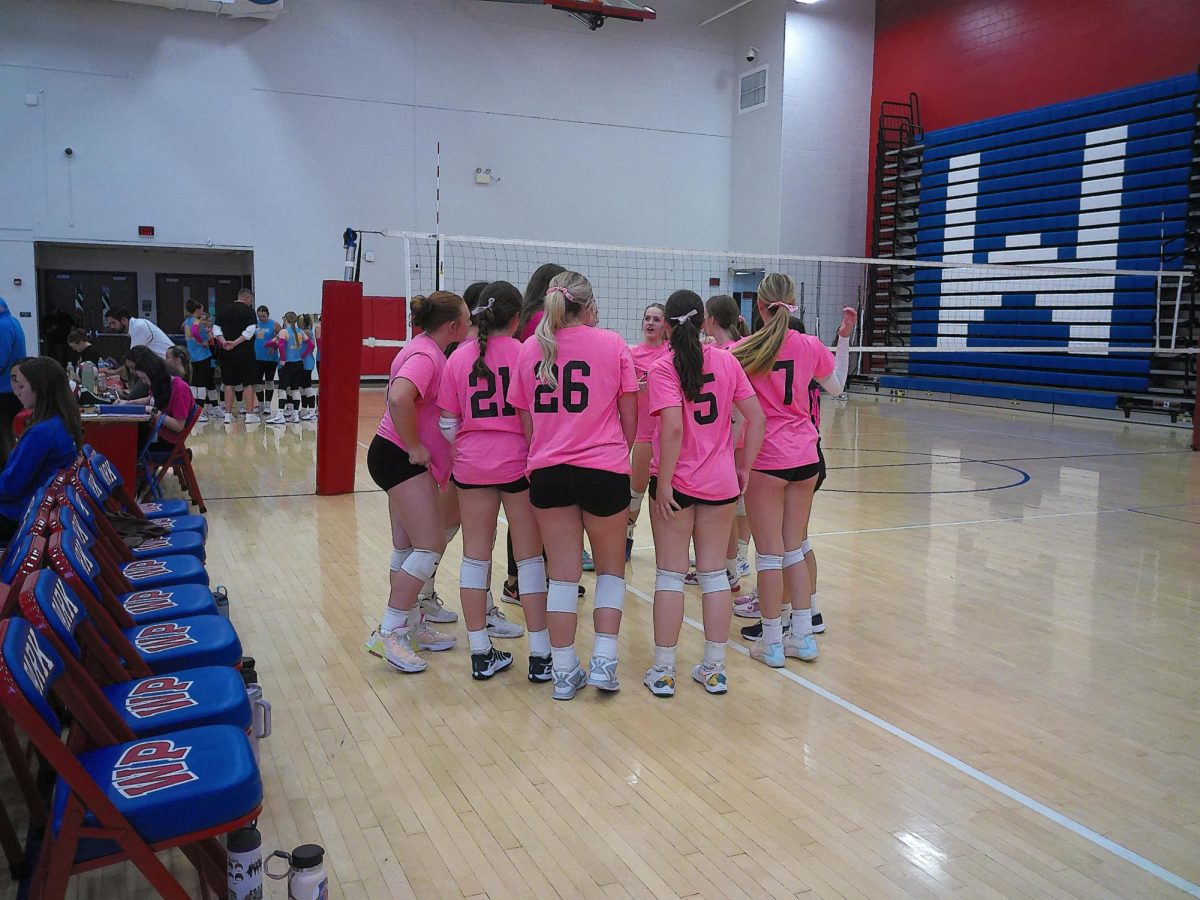 The Volleyball team prepares for their game on Breast Cancer Awareness night. 