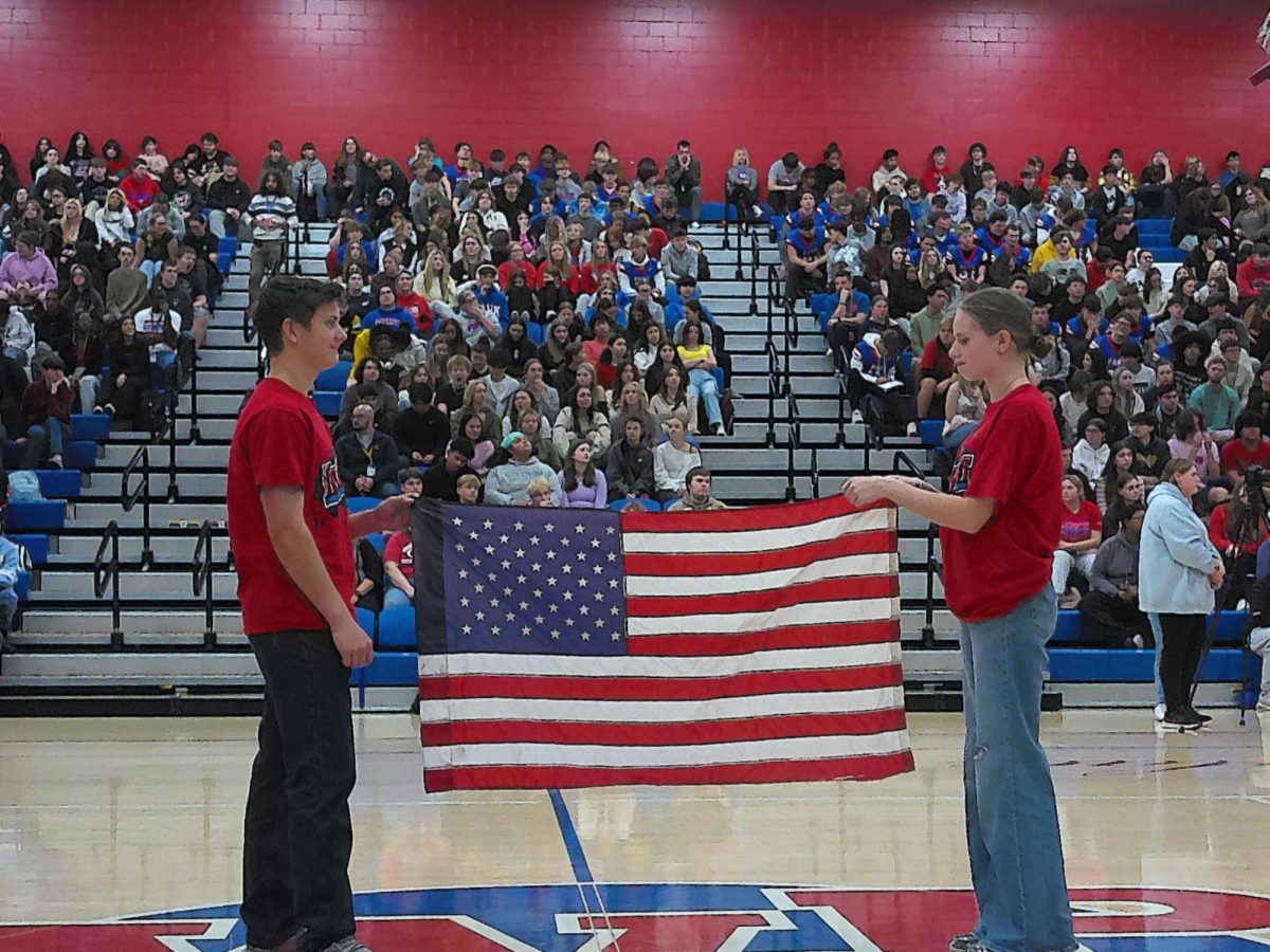 Students demonstrate the proper way to honor the flag of the United States of America.