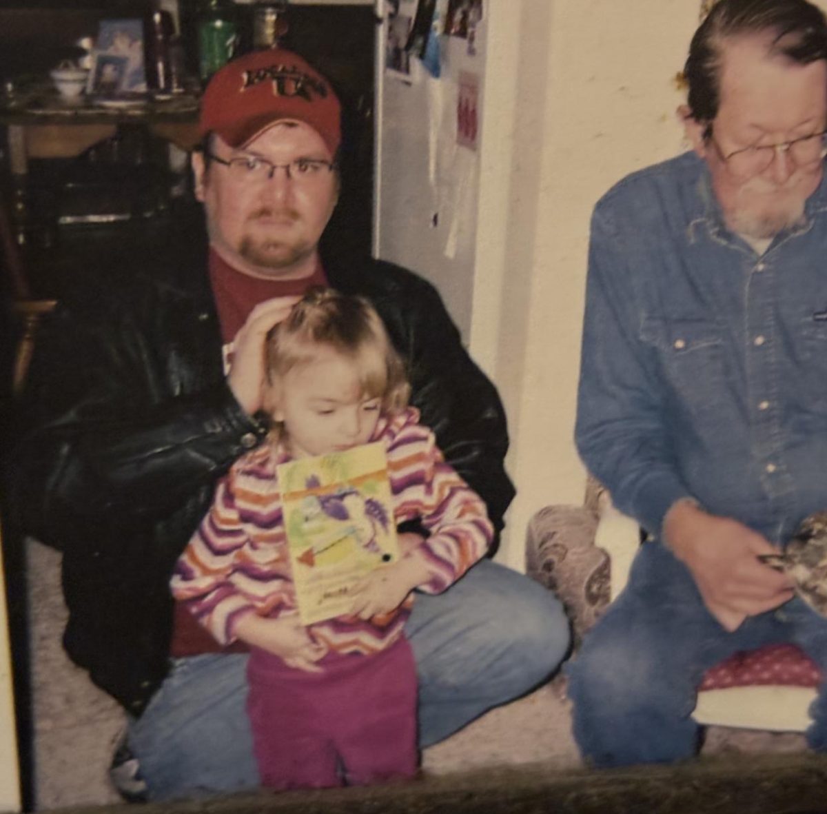 My dad (Joseph Schmidt) holding me (Jessamine Schmidt), sitting next to my grandpa (Thomas Schmidt) while at my third birthday party. 