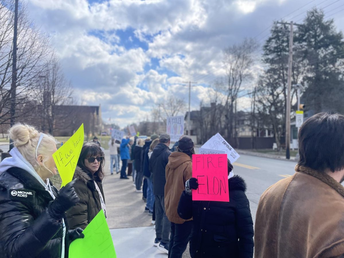 The growing crowd protests against Elon Musk and corporate influence. 