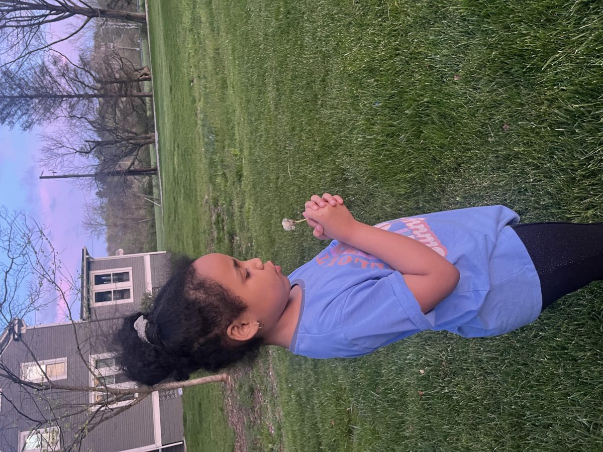 Cali's attempt of blowing dandelion away on last few days of spring break.