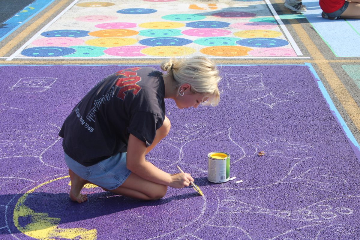 Victoria Canestraro focuses on painting inside the lines of her spot. 