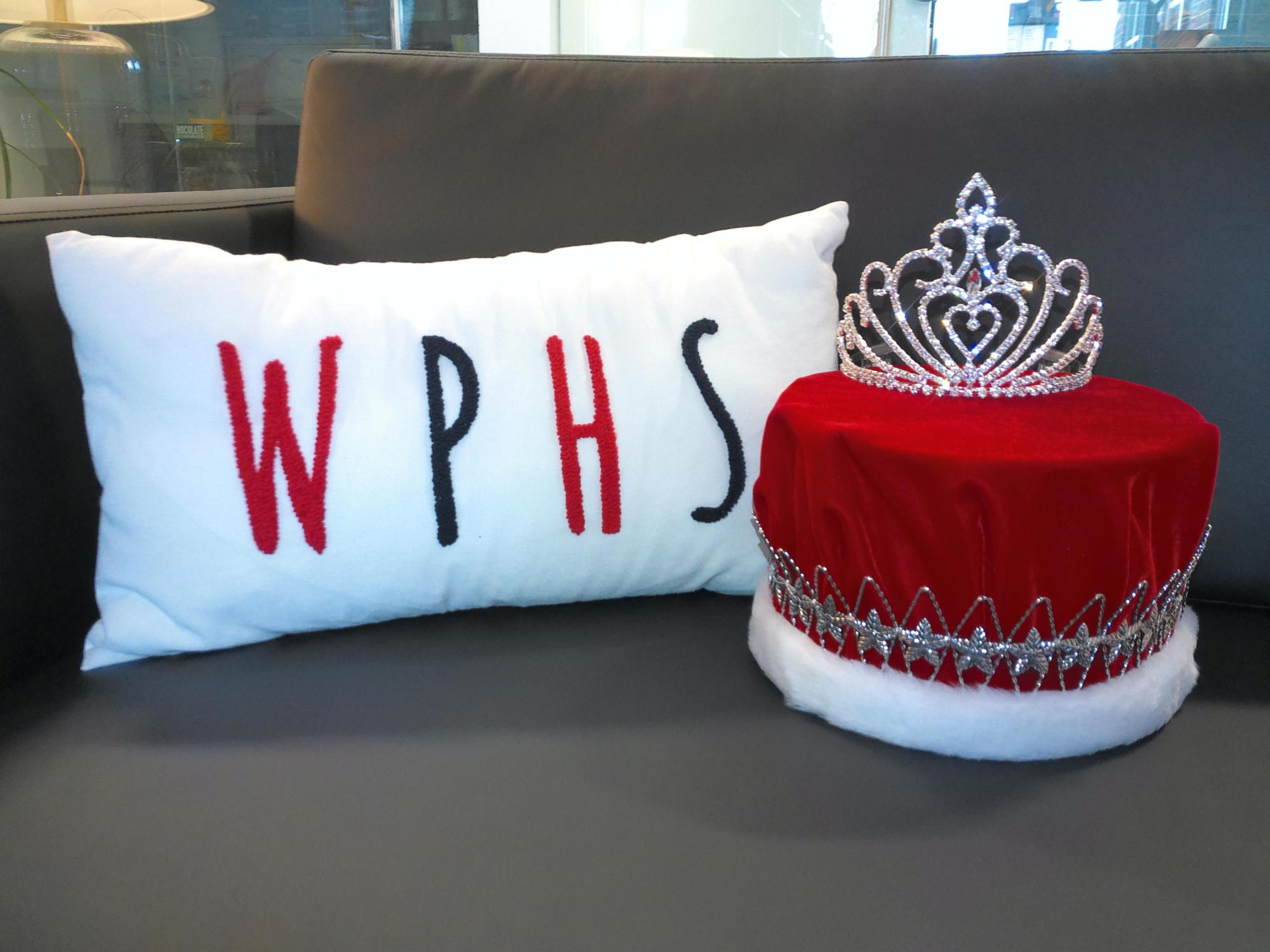 The crowns of the Homecoming King and Queen sit by a Wheeling Park sign. 