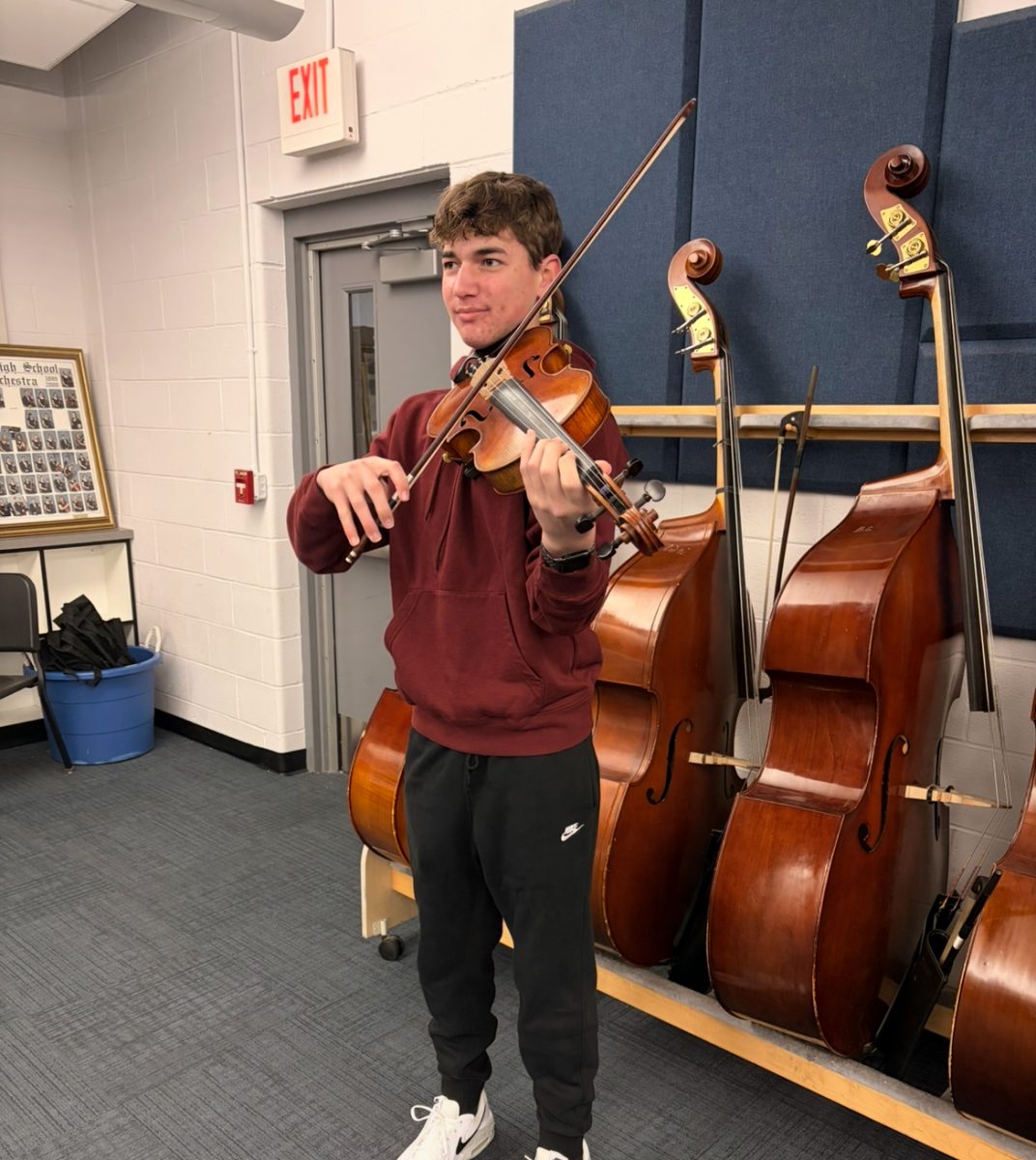 Jaxon plays his violin in the strings room at Park.