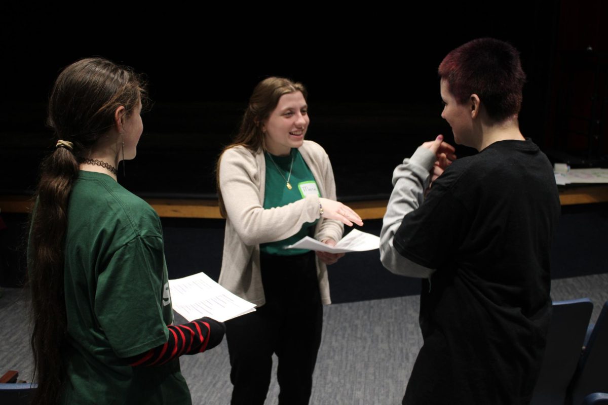 Maria Faulstick works with two middle schoolers on Duo, an interpretative event where students perform a two-person script.