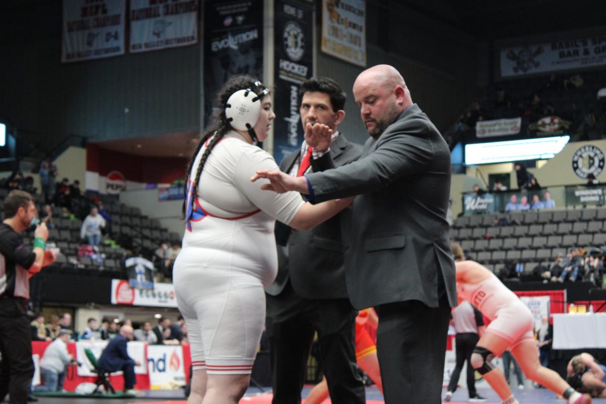 Coach Doyle readys Gibbons on the mat.