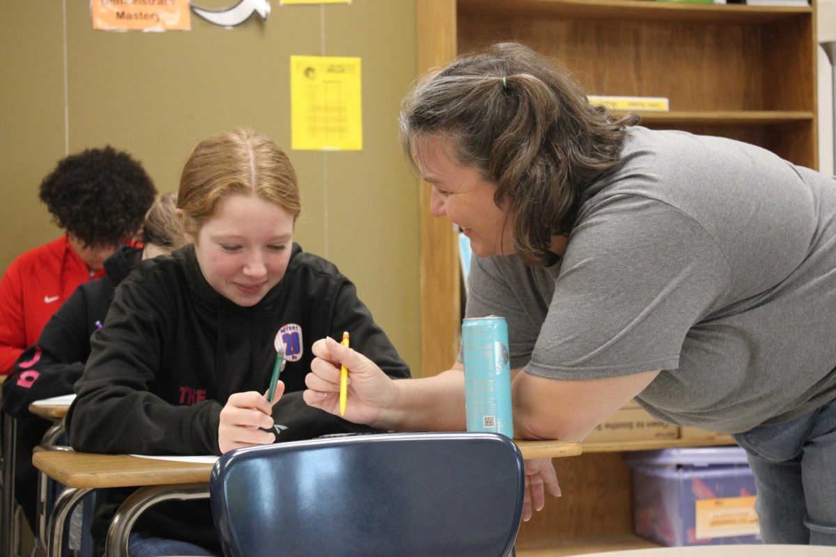 Mrs. Crews helps a student in her first period class with a smile on her face. Crews is known for finding a solution with a positive outlook! 
