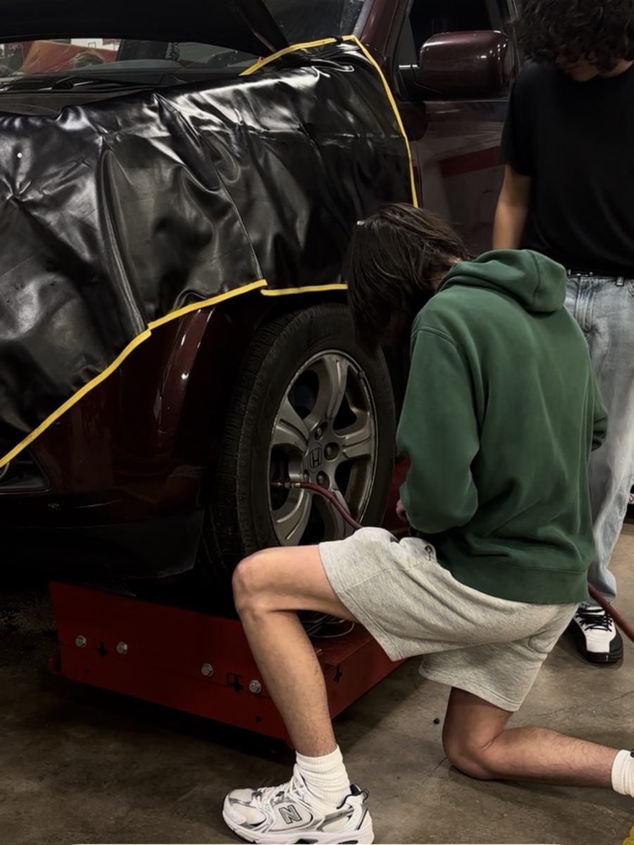 Students work on a car within the automotive garage. 