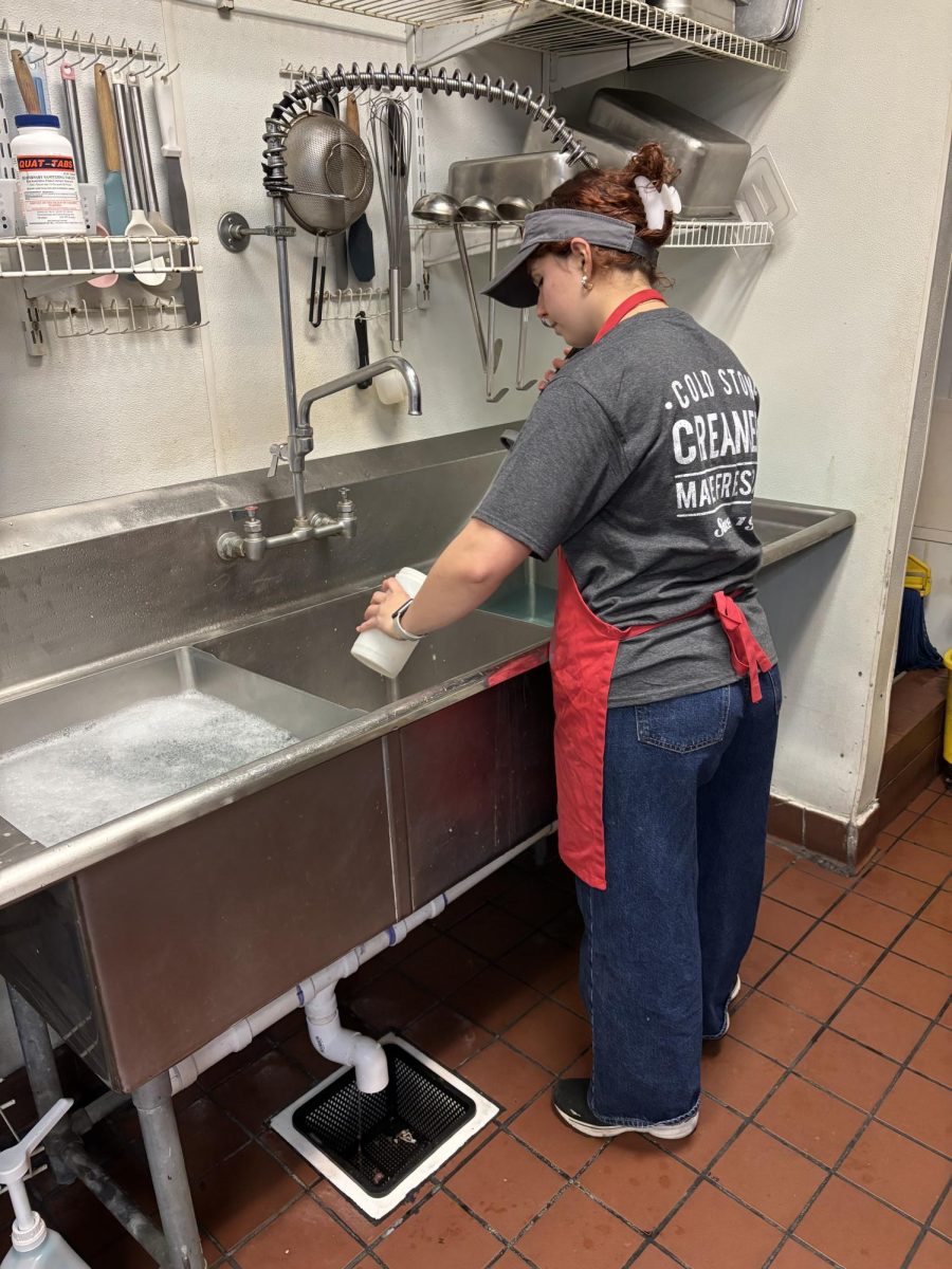 Lucrezia Santini preparing to close the store by washing dishes